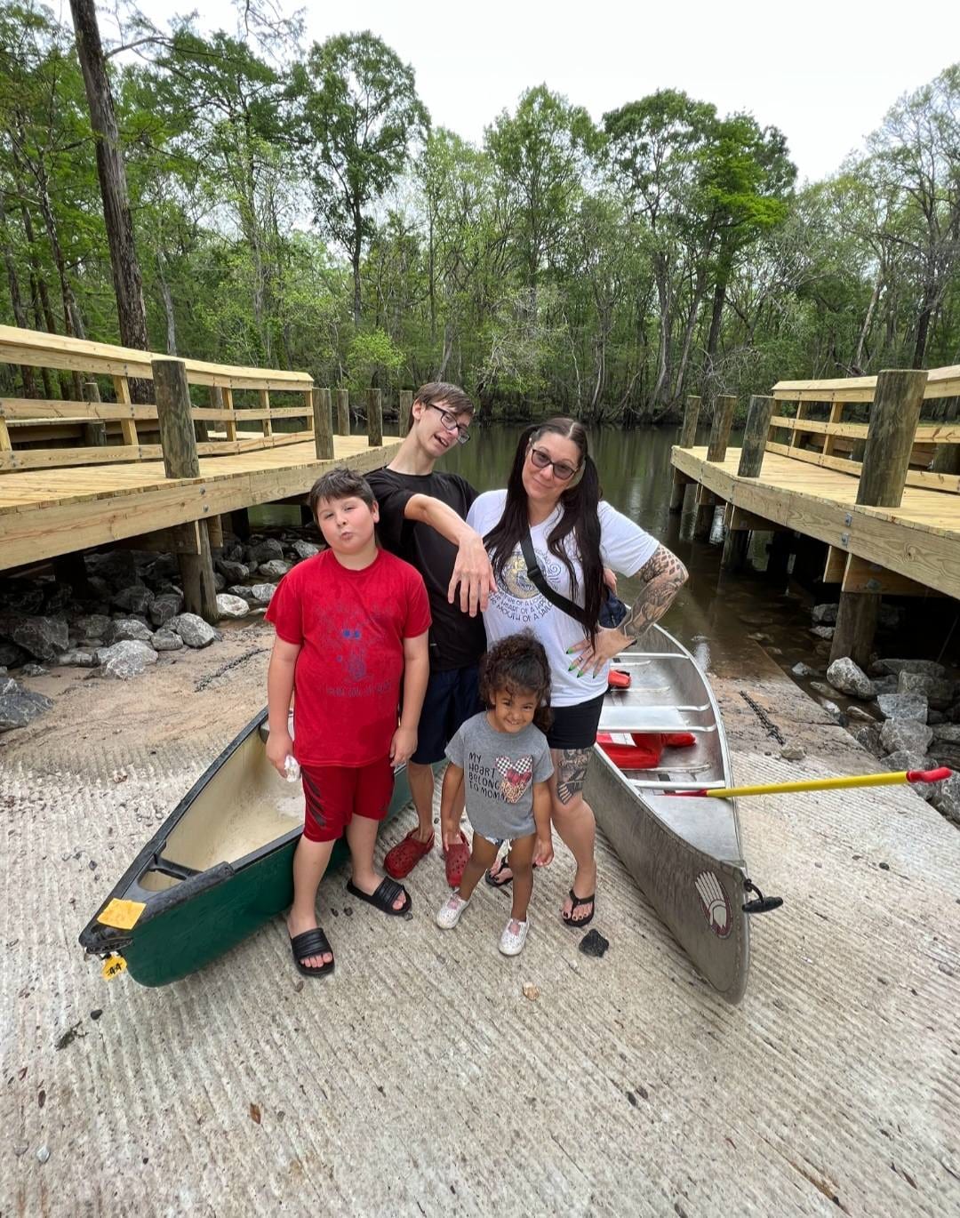 Crystal enjoying an outdoor day with family beside two canoes