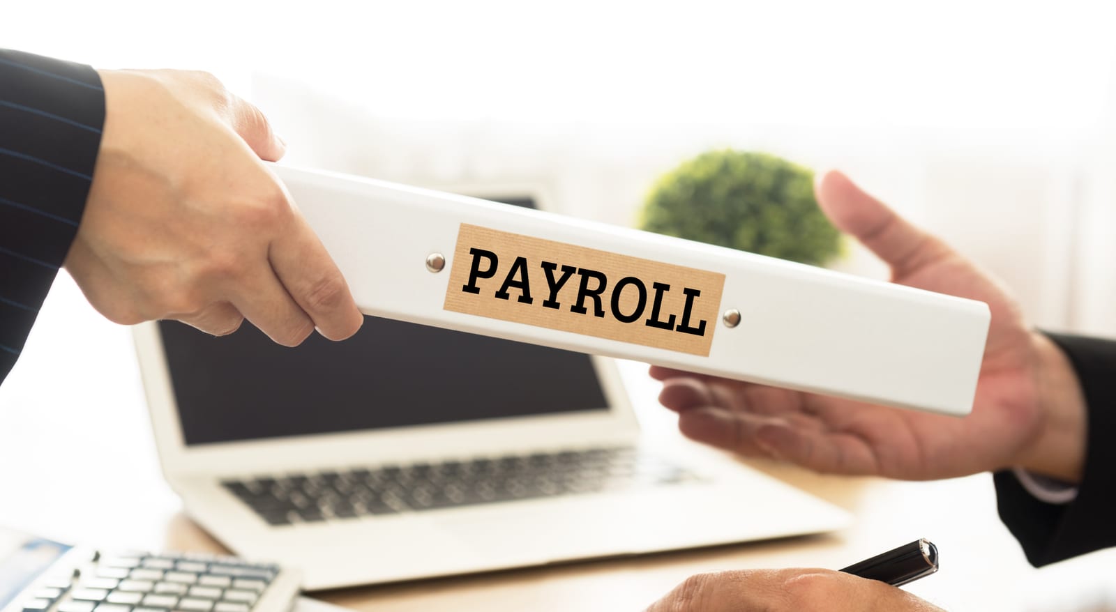 A payroll envelope being handed across a desk